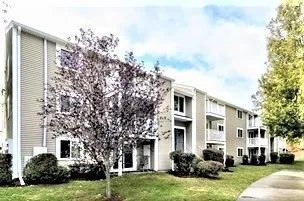 a front view of a house with a garden and trees