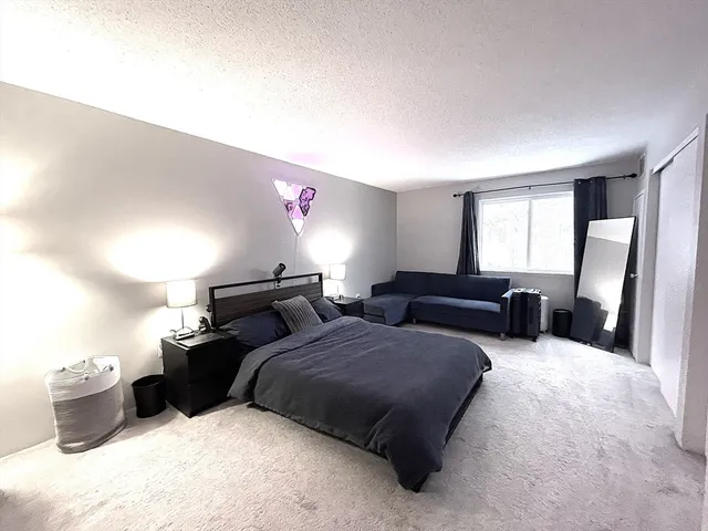 a bedroom with furniture and a large window