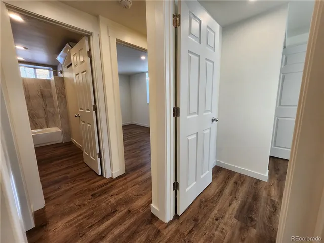 a view of a hallway with wooden floor and staircase