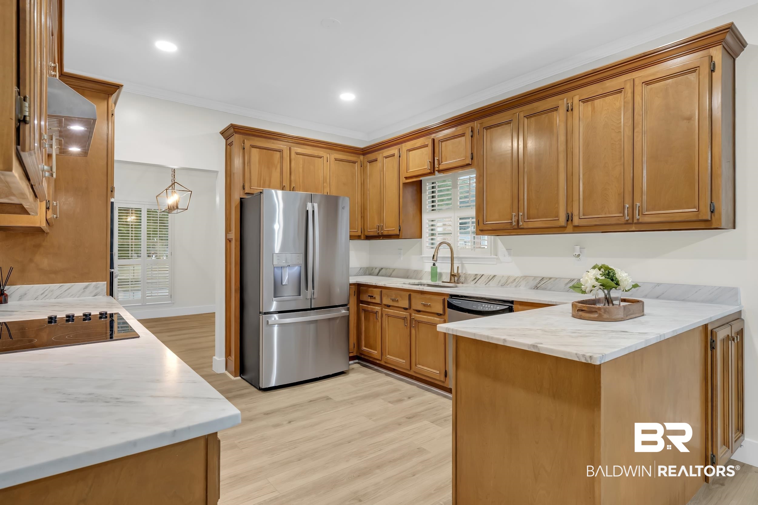 4924 Brooke Court Mobile, AL 36618 - Photo 13 of 34 Kitchen featuring brown cabinets, black appliances, a peninsula, light wood-style floors, and plenty of natural light