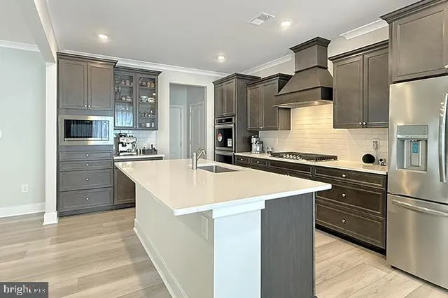 a kitchen with stainless steel appliances kitchen island a sink stove and refrigerator