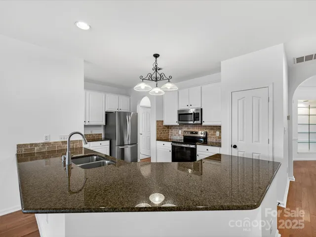 a kitchen with kitchen island a counter top a stove a sink and a refrigerator