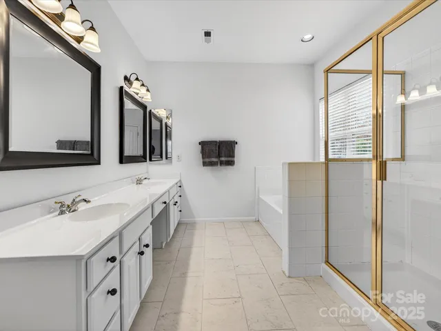 a spacious bathroom with a double vanity sink a mirror and a shower