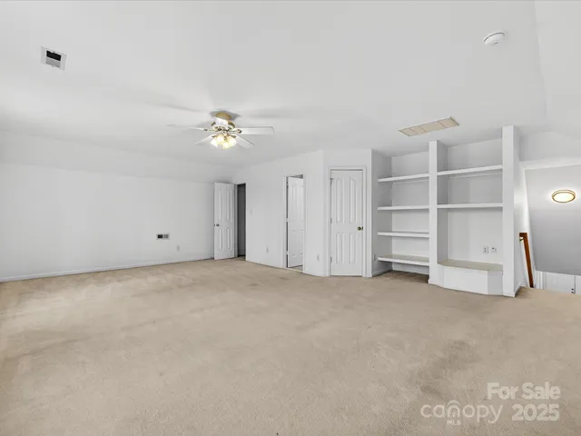 a view of an empty room with a ceiling fan