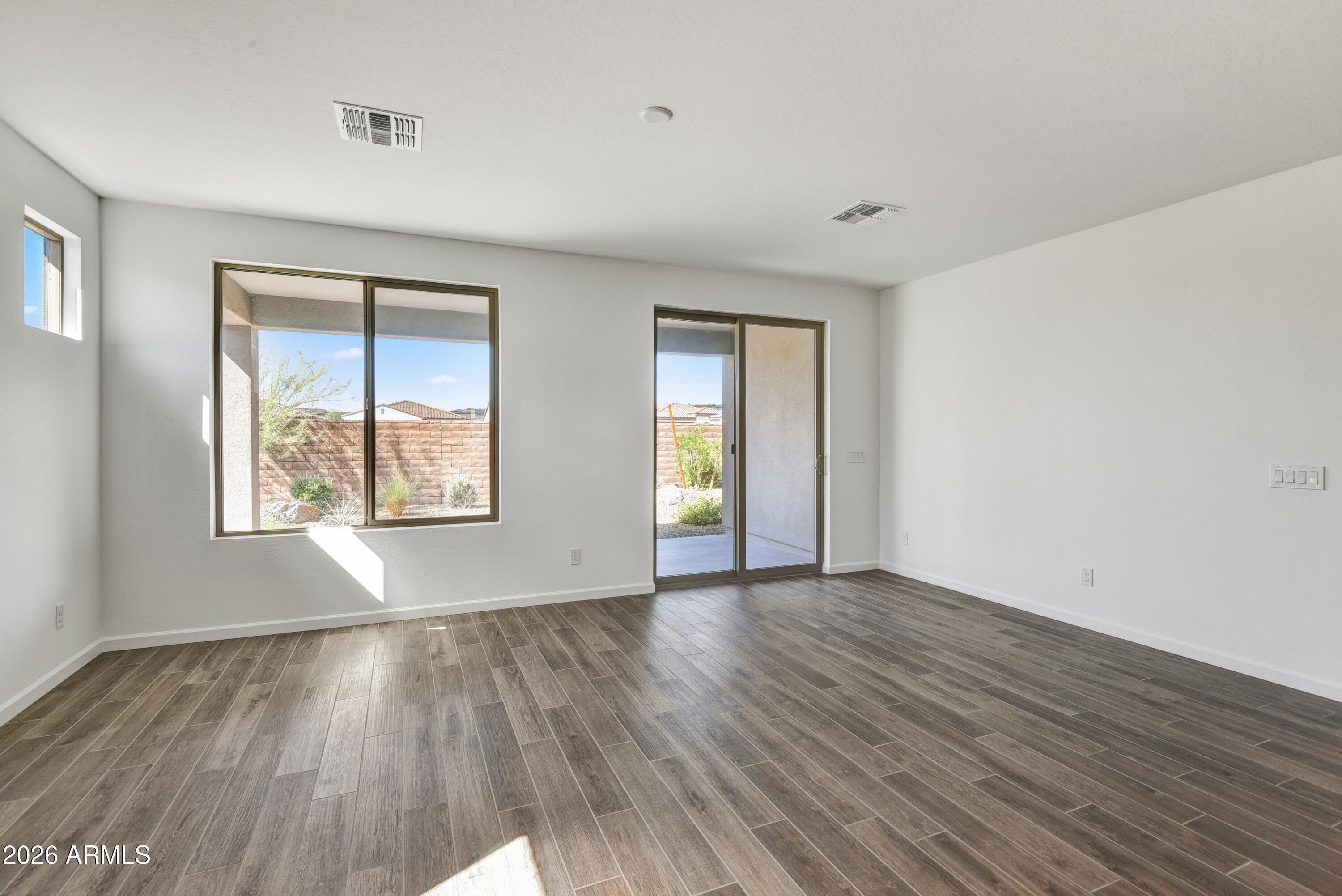4522 Jackpot Road Wickenburg, AZ 85390 - Photo 9 of 22 a view of an empty room with wooden floor and a window