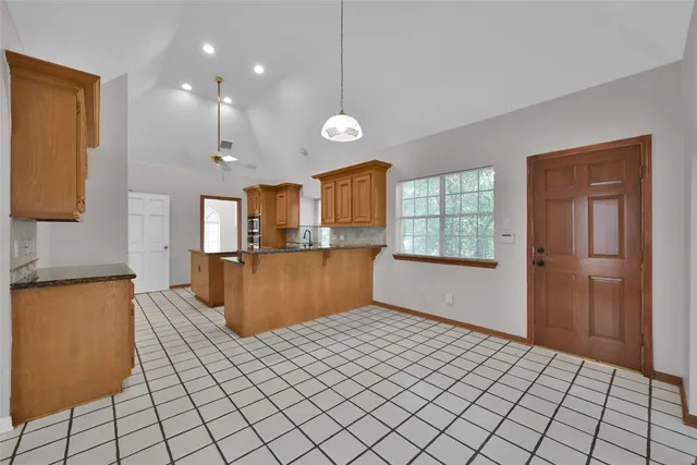 a kitchen with stainless steel appliances kitchen island granite countertop a refrigerator a stove top oven and a sink with granite countertops