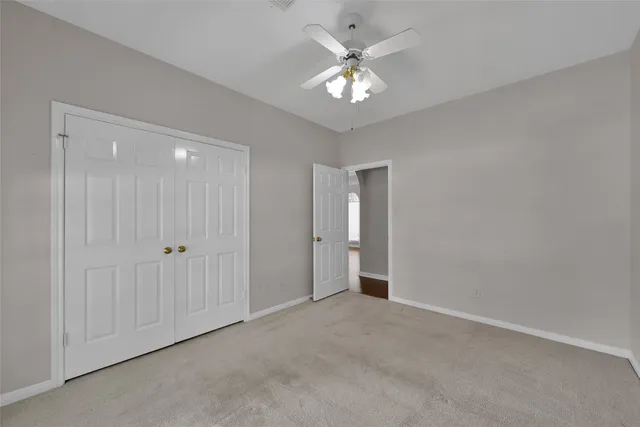 a view of an empty room with a chandelier fan