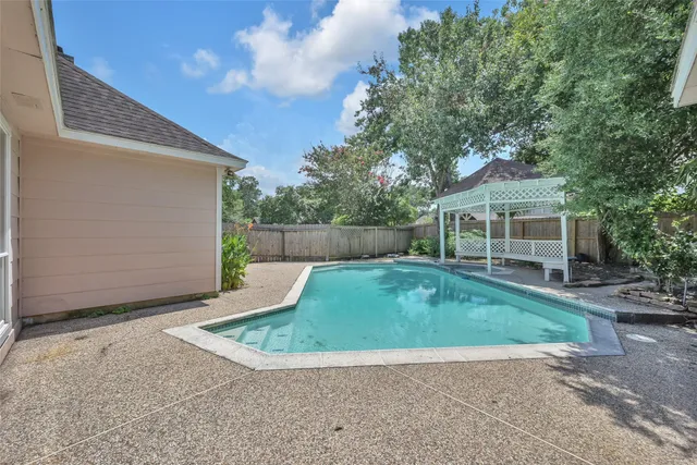 a view of a house with backyard and a tree