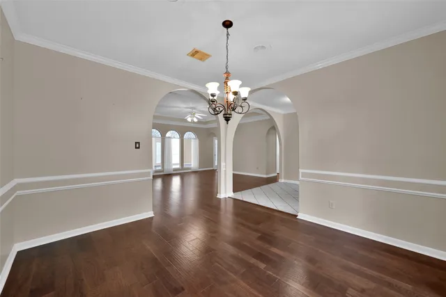 a view of a chandelier in big room with wooden floor