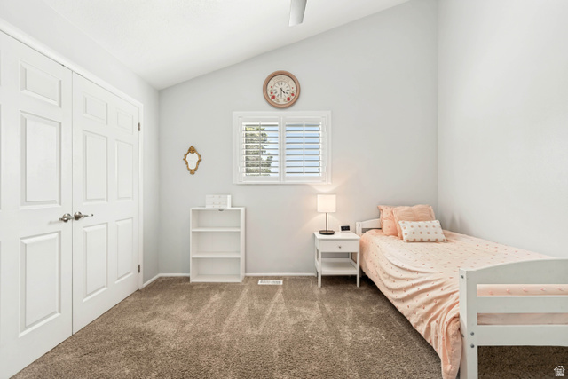 9832 Falconhurst Drive Sandy, UT 84092 - Photo 14 of 29 Room featuring a vaulted ceiling with a ceiling fan, plush carpet flooring, a window with white louvered shutters, and a double-door closet