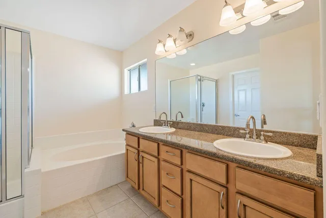 a bathroom with a granite countertop sink a mirror a bathtub and shower
