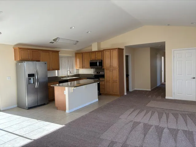 a kitchen with stainless steel appliances granite countertop a refrigerator and a stove