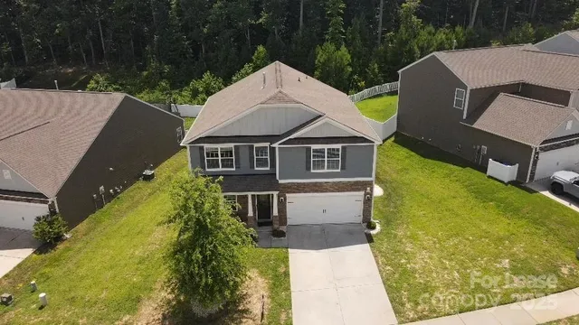 a aerial view of a house with a yard and a garage