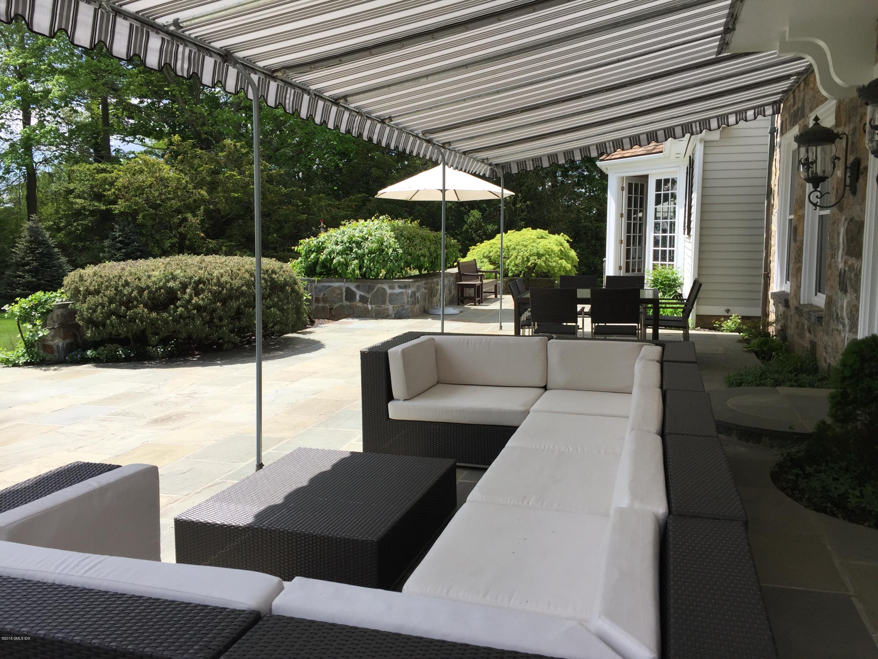 5 Dairy Road Greenwich, CT 06830 - Photo 29 of 32 a view of a patio with couches table and chairs with an umbrella