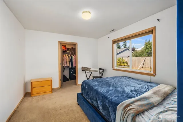 a bedroom with a bed and a painting on the wall