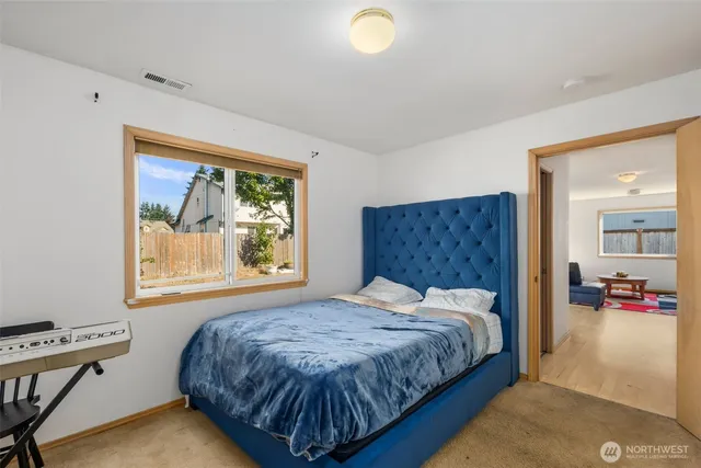 a bedroom with a bed and dresser with mirror