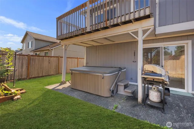 a view of a backyard with a tub and wooden fence
