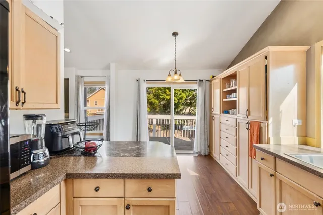 a kitchen with stainless steel appliances granite countertop a stove and a wooden floors