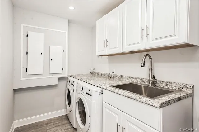 a view with granite countertop white cabinets and sink