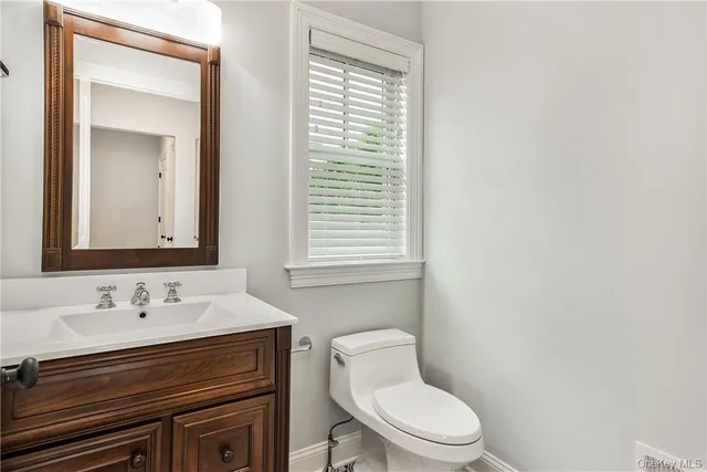 a bathroom with a toilet a sink and mirror