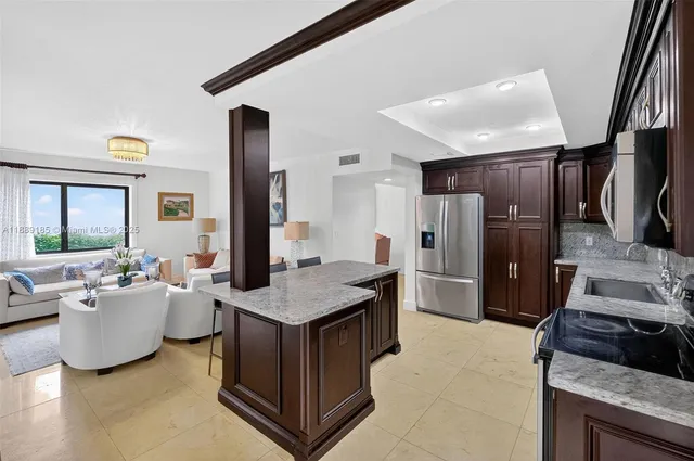 a kitchen with stainless steel appliances granite countertop a refrigerator and a sink