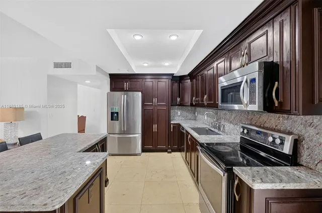 a kitchen with stainless steel appliances granite countertop a sink stove and refrigerator