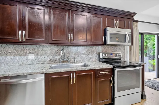 a kitchen with granite countertop cabinets stainless steel appliances and a counter top space