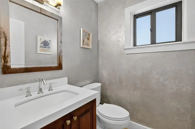 a bathroom with a sink vanity mirror and toilet