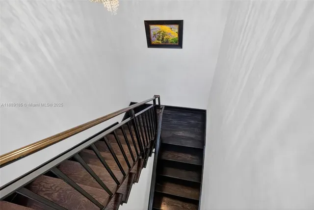 a view of a hallway with wooden floor and a potted plant