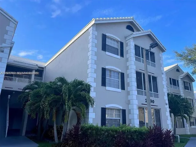 a view of a building with a plants and palm trees