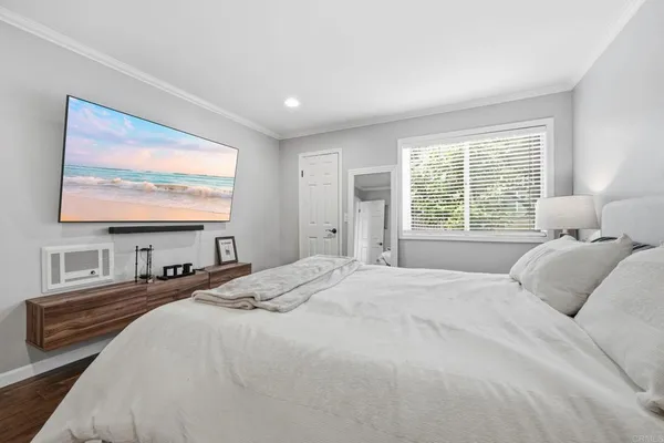 a bedroom with a bed and painting on the wall