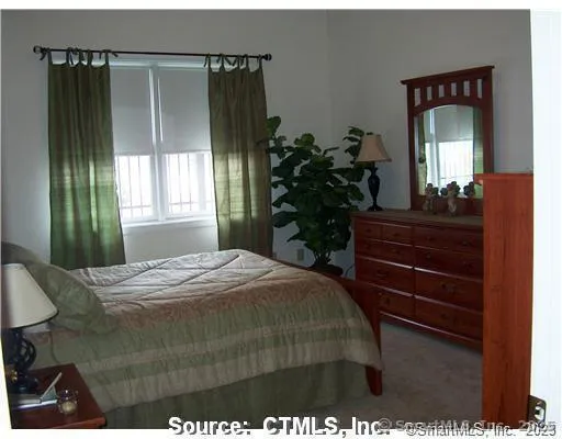 a bedroom with a bed and a potted plant
