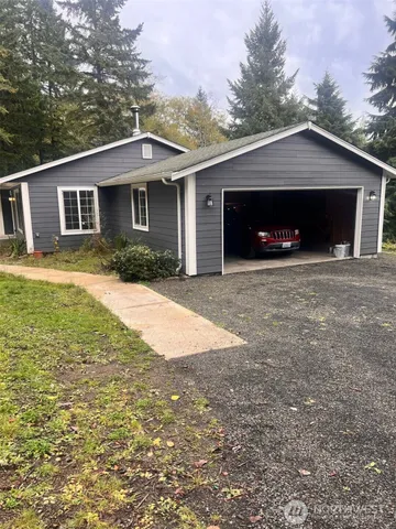 a front view of a house with yard and trees