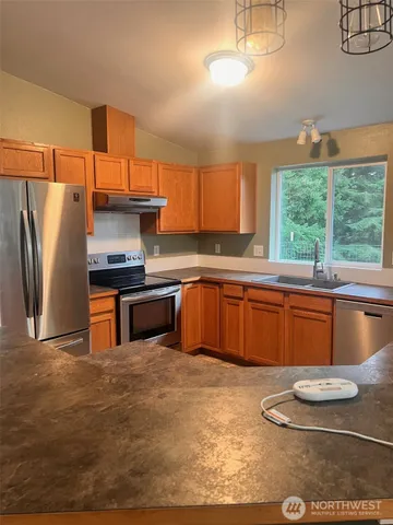 a kitchen with stainless steel appliances granite countertop a sink and a stove