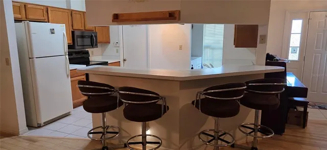 a kitchen with stainless steel appliances a dining table chairs and a refrigerator