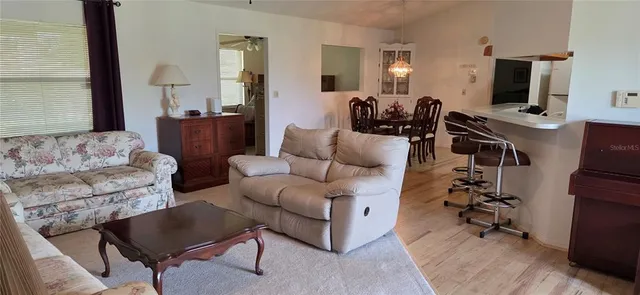 a living room with furniture a flat screen tv and a window