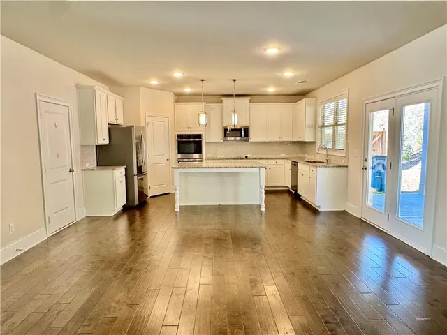 a large kitchen with a large counter top appliances and cabinets