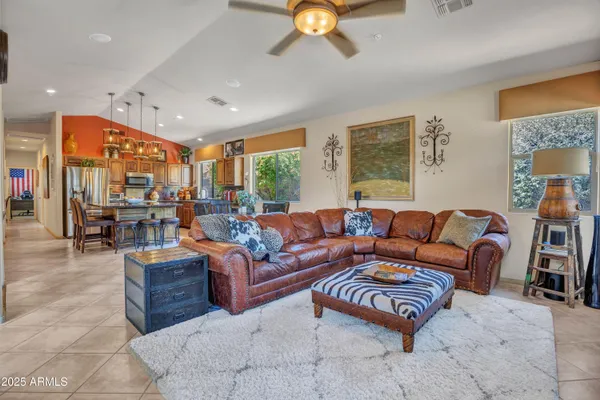 a living room with furniture kitchen view and a chandelier