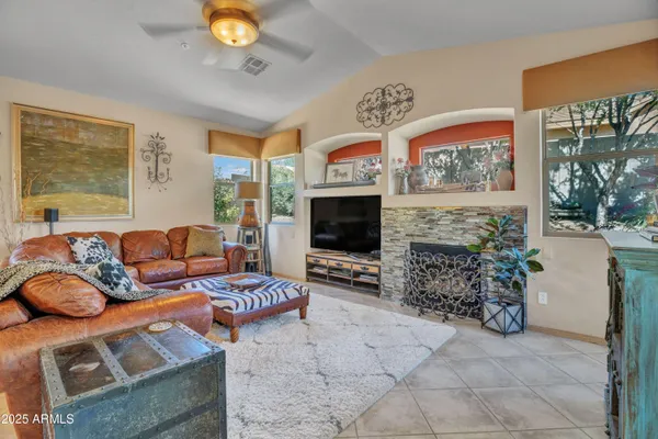 a living room with furniture a flat screen tv and a fireplace