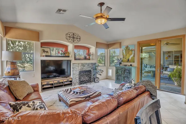 a living room with furniture a flat screen tv and a fireplace