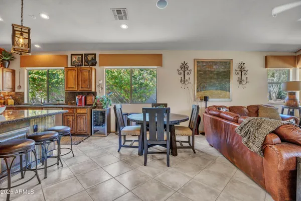 a living room with furniture a large window and dining table