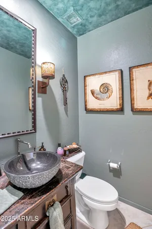 a bathroom with a granite countertop toilet sink and mirror