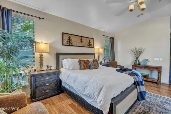 a bedroom with a bed and large windows