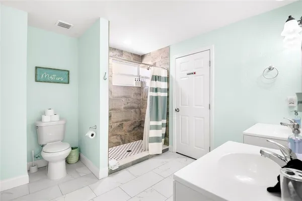 a bathroom with a sink a toilet and shower