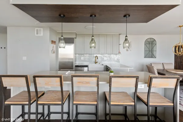 a living room with a table chairs and a dining table with wooden floor