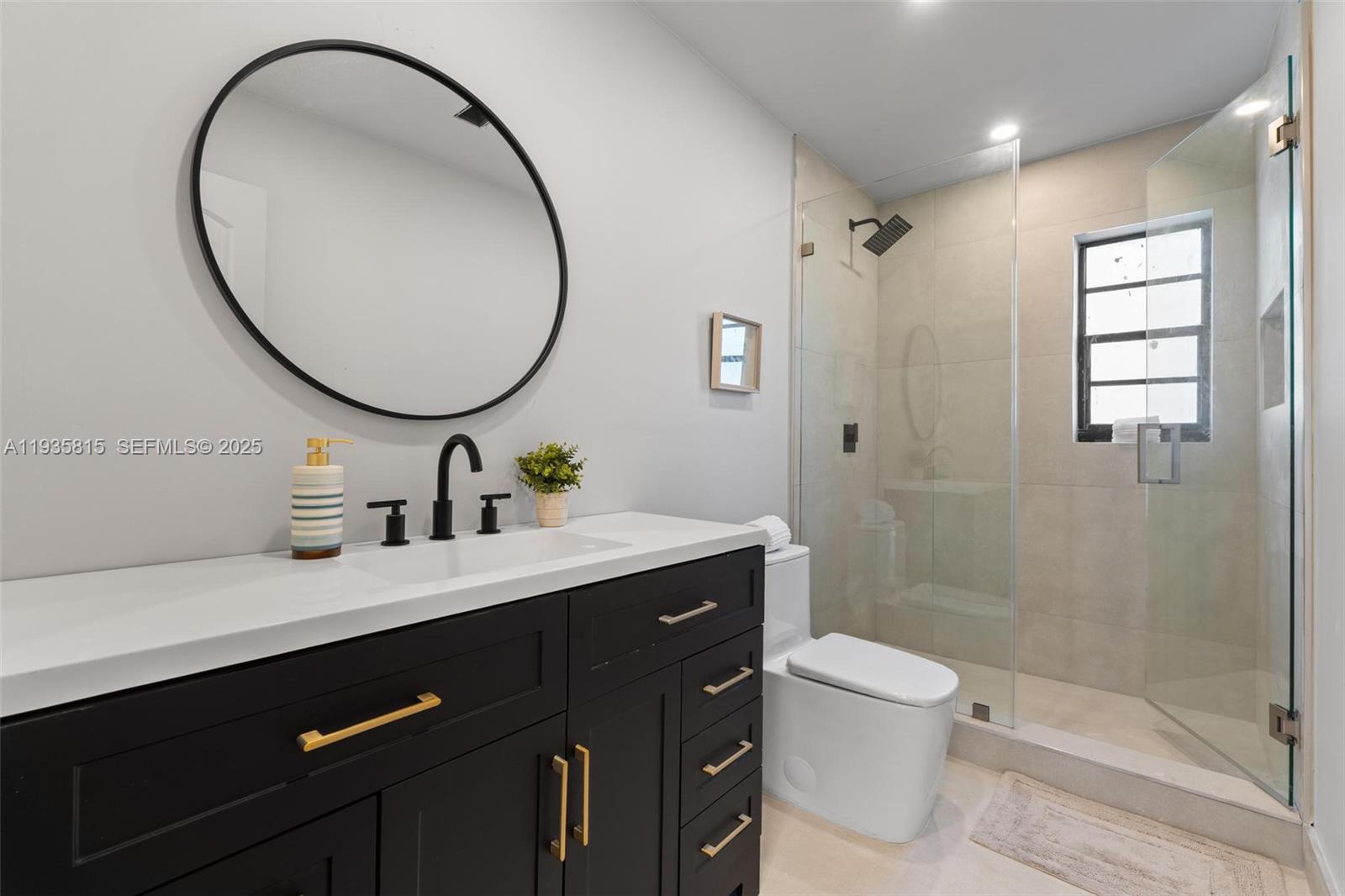 2439 Rodman Street Hollywood, FL 33020 - Photo 20 of 28 a bathroom with a sink a toilet and a mirror