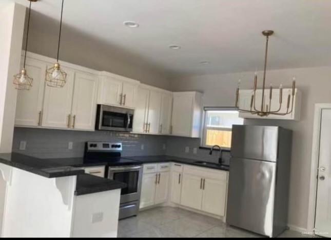 5805 Puffin Avenue, Unit 1 Mission, TX 78573 - Photo 3 of 7 a kitchen with stainless steel appliances granite countertop a refrigerator a stove a sink a microwave and a refrigerator