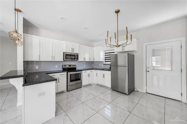 a kitchen with stainless steel appliances granite countertop a refrigerator a stove a sink dishwasher and a refrigerator