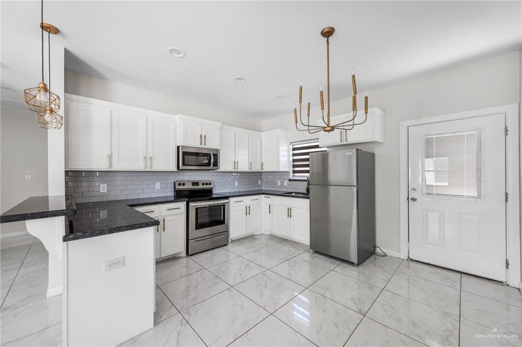 5805 Puffin Avenue, Unit 1 Mission, TX 78573 - Photo 4 of 7 a kitchen with stainless steel appliances granite countertop a refrigerator a stove a sink dishwasher and a refrigerator