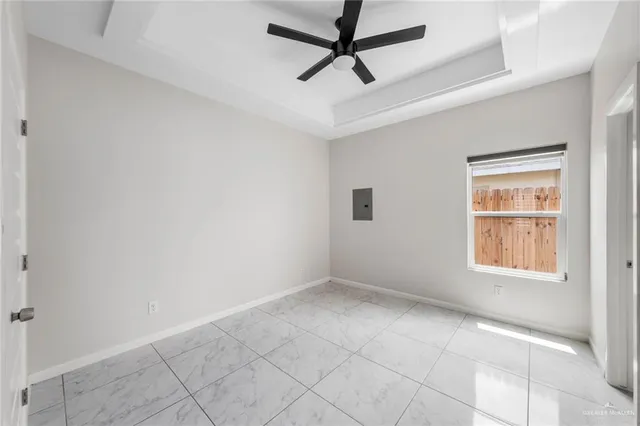 an empty room with windows and fan